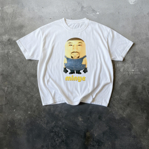 White t-shirt printed with a yellow cartoon figure in denim overalls with a man's photographed face, labeled minye.