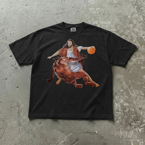 Black t-shirt printed with a painted robed figure holding a basketball above a fallen red horned devil.