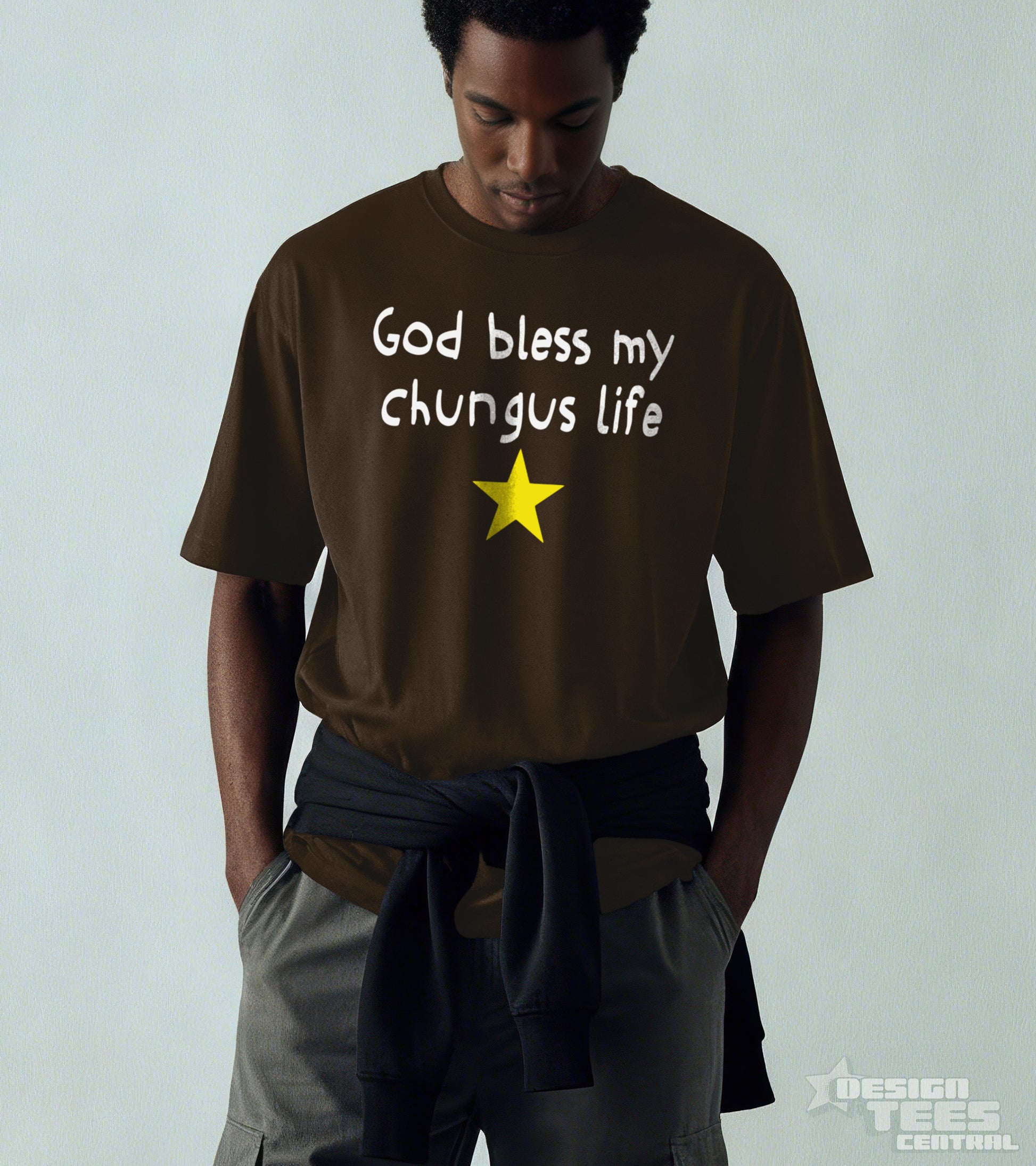 Person wearing a brown t-shirt with 'God bless my chungus life' text and a yellow star on a plain background