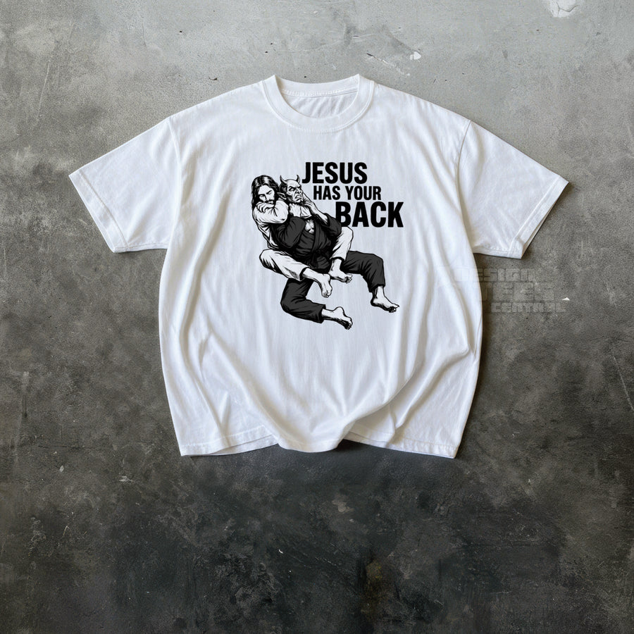 White t-shirt printed with an ink drawing of a bearded figure grappling a horned demon and the text Jesus Has Your Back.